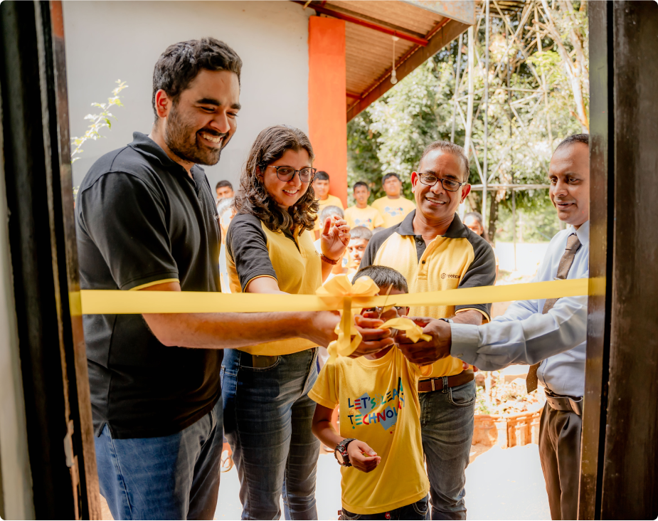 Rootcode CEO, COO and the president of the Rootcode Foundation cutting the ribbon of the computer lab along with a student and the principal