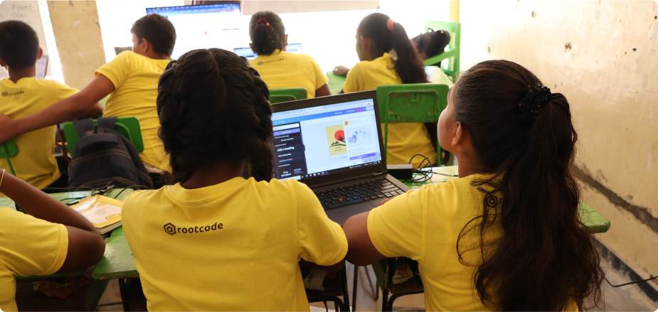 Students wearing Rootcode Foundation tshirts learning Canva